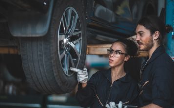 So sparen Sie clever: Exklusive Werkstattvorteile bei DRIVER für ARCD-Mitglieder Ein weiblicher und ein männlicher Automechaniker prüfen den Reifen an einem aufgebockten Fahrzeug