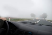 Sicher unterwegs im Herbst: Sehen und gesehen werden Blick durch die Windschutzscheibe eines Autos auf ein entgegenkommendes Fahrzeug im Nebel