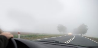 Sicher unterwegs im Herbst: Sehen und gesehen werden Blick durch die Windschutzscheibe eines Autos auf ein entgegenkommendes Fahrzeug im Nebel